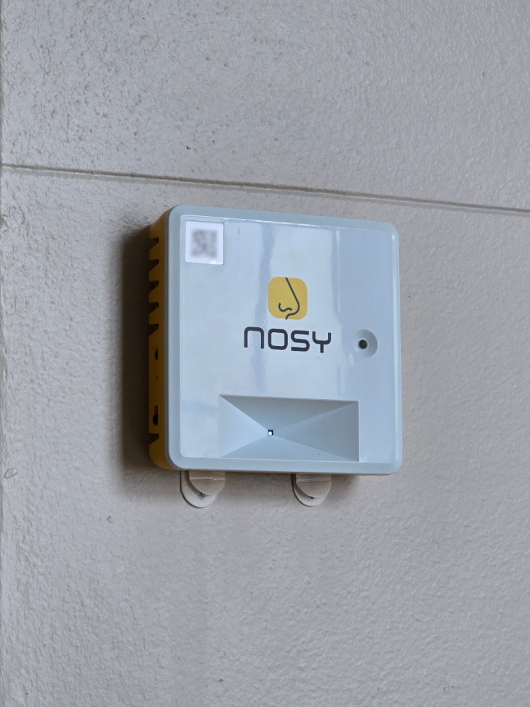 A Nosy building sensor mounted on a wall